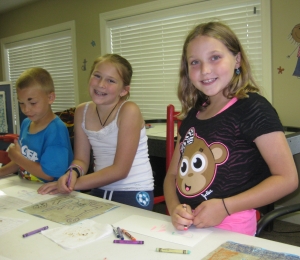 Three of our campers from week 1 doing arts and crafts!